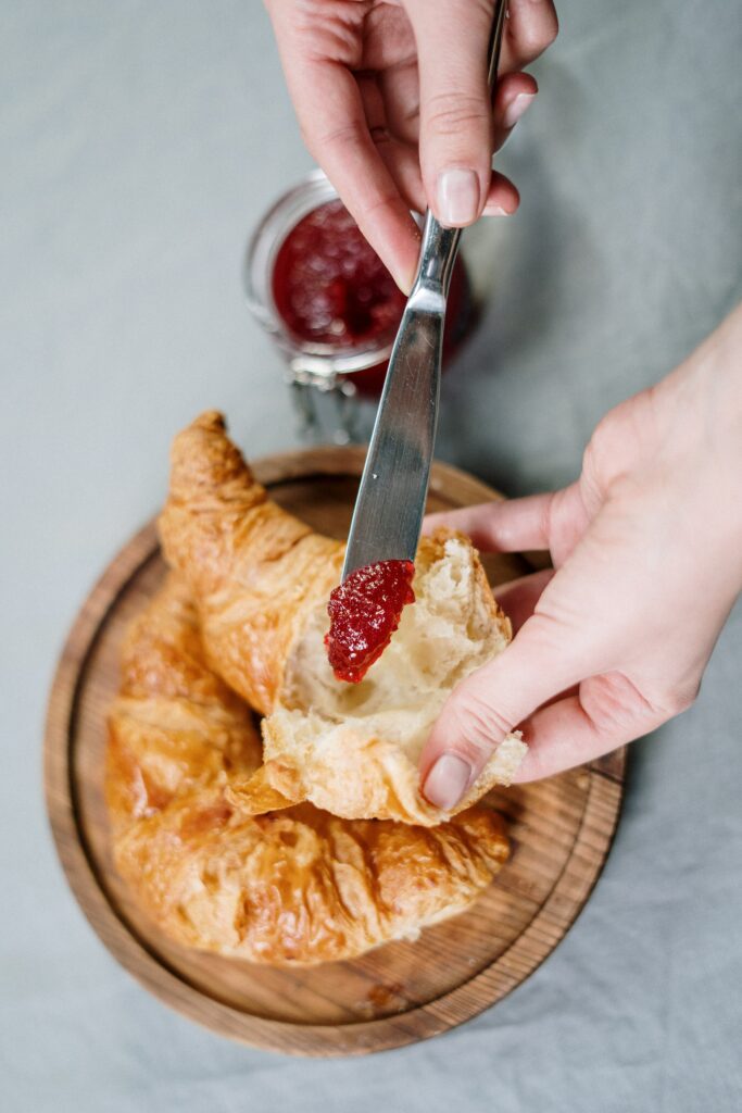 Croissant au beurre et confiture, un petit déjeuner français trop riche en graisses et en sucres. 